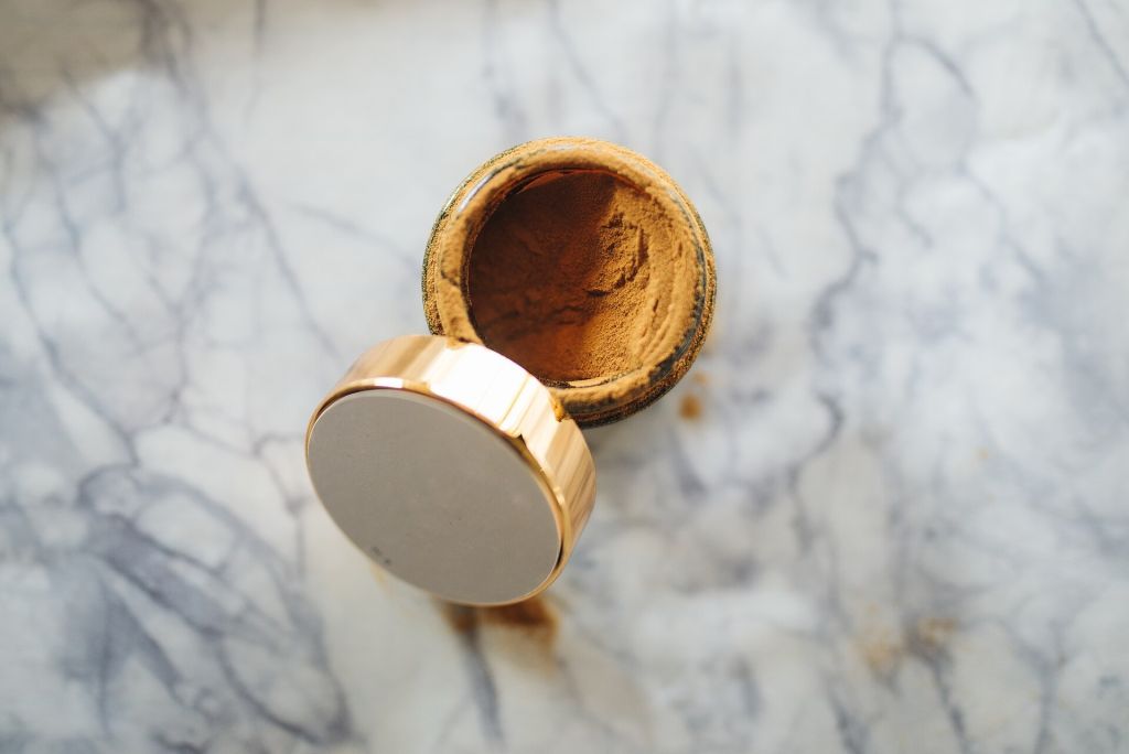 Jar of herbal powder on marble