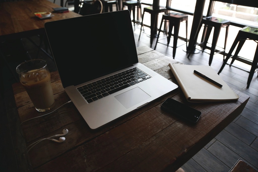 Laptop and notebook on a cafe table