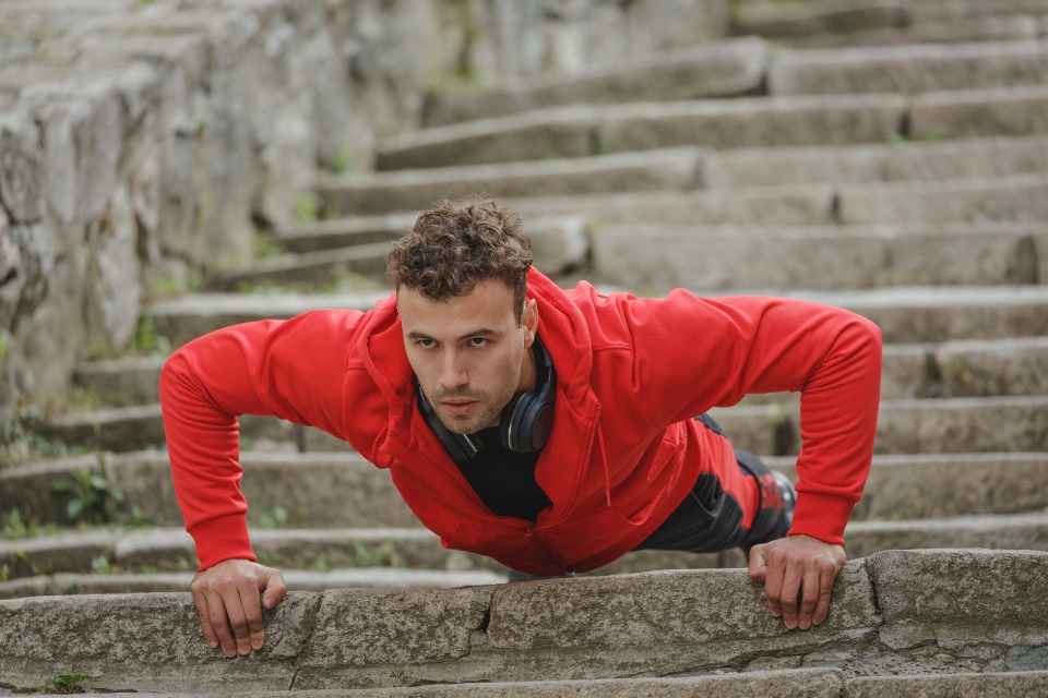 Man doing push-ups on outdoor steps