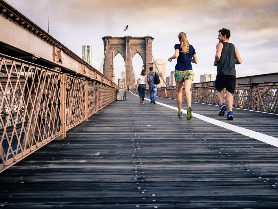 Runners crossing a bridge in the morning