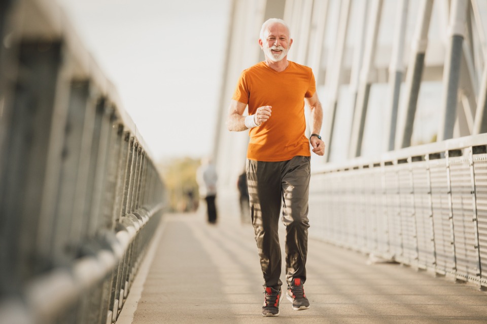 Older man running across a bridge