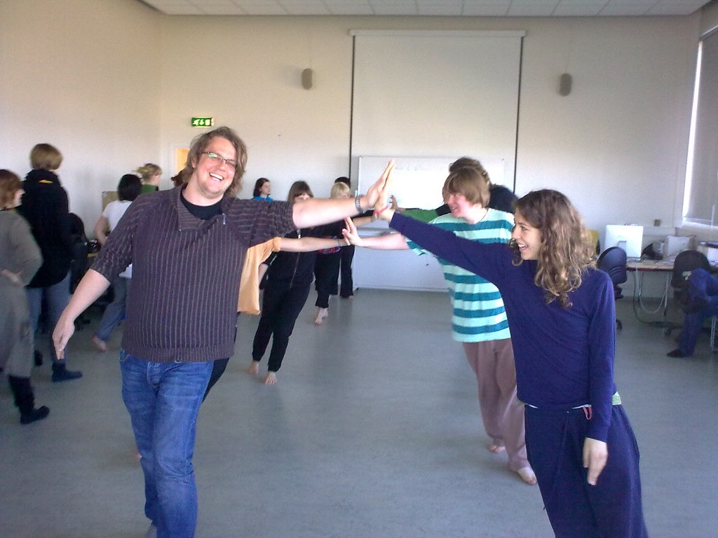 Group doing warm-up exercises in a hall