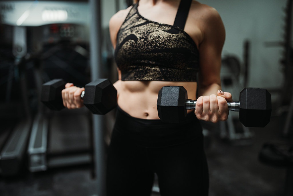 Strong woman lifting dumbbells